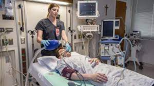 A respiratory therapist manually ventilates a patient.